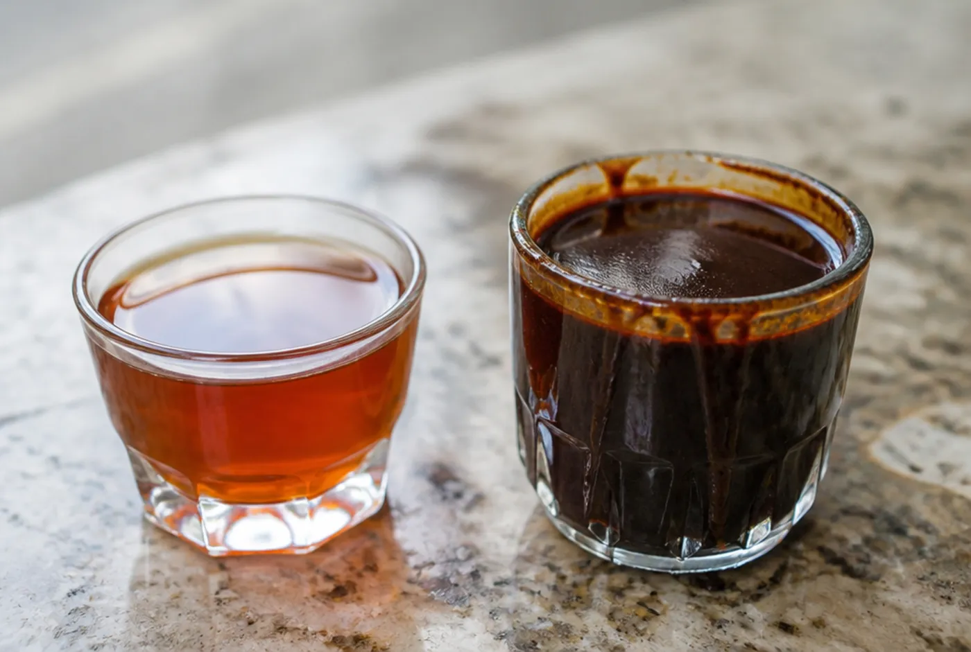 Two glasses of black coffee side by side: one thin and tea-like, one thick and velvety