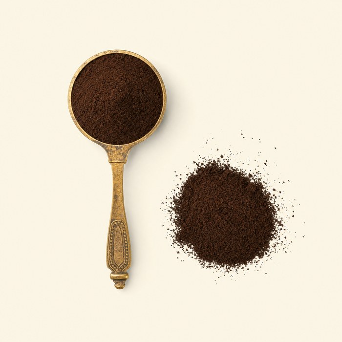 A brass scoop of powder-fine Turkish coffee on a warm cream ground