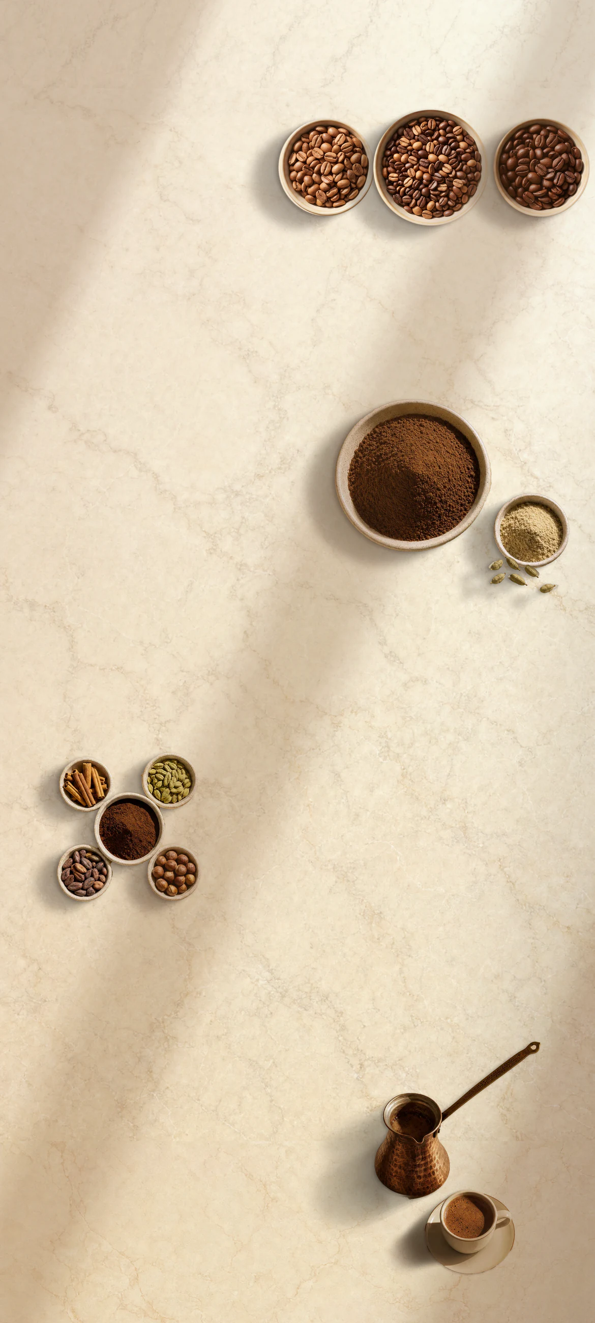 Coffee beans, powder-fine coffee and cardamom, blend ingredients, and a copper cezve with a white cup laid out on continuous warm plaster