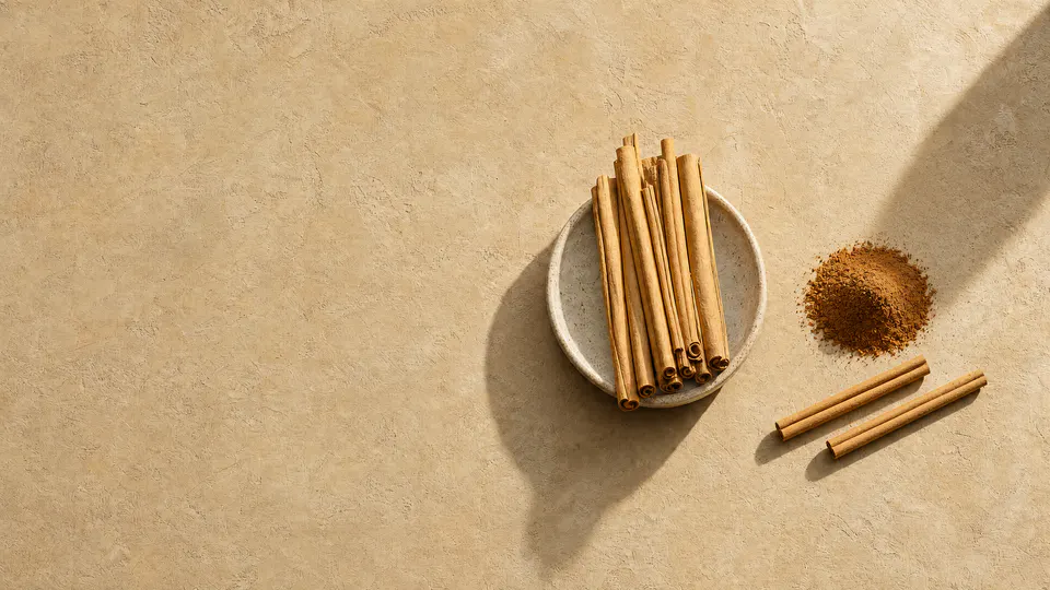 Organic cinnamon sticks and ground organic cinnamon on warm textured stone