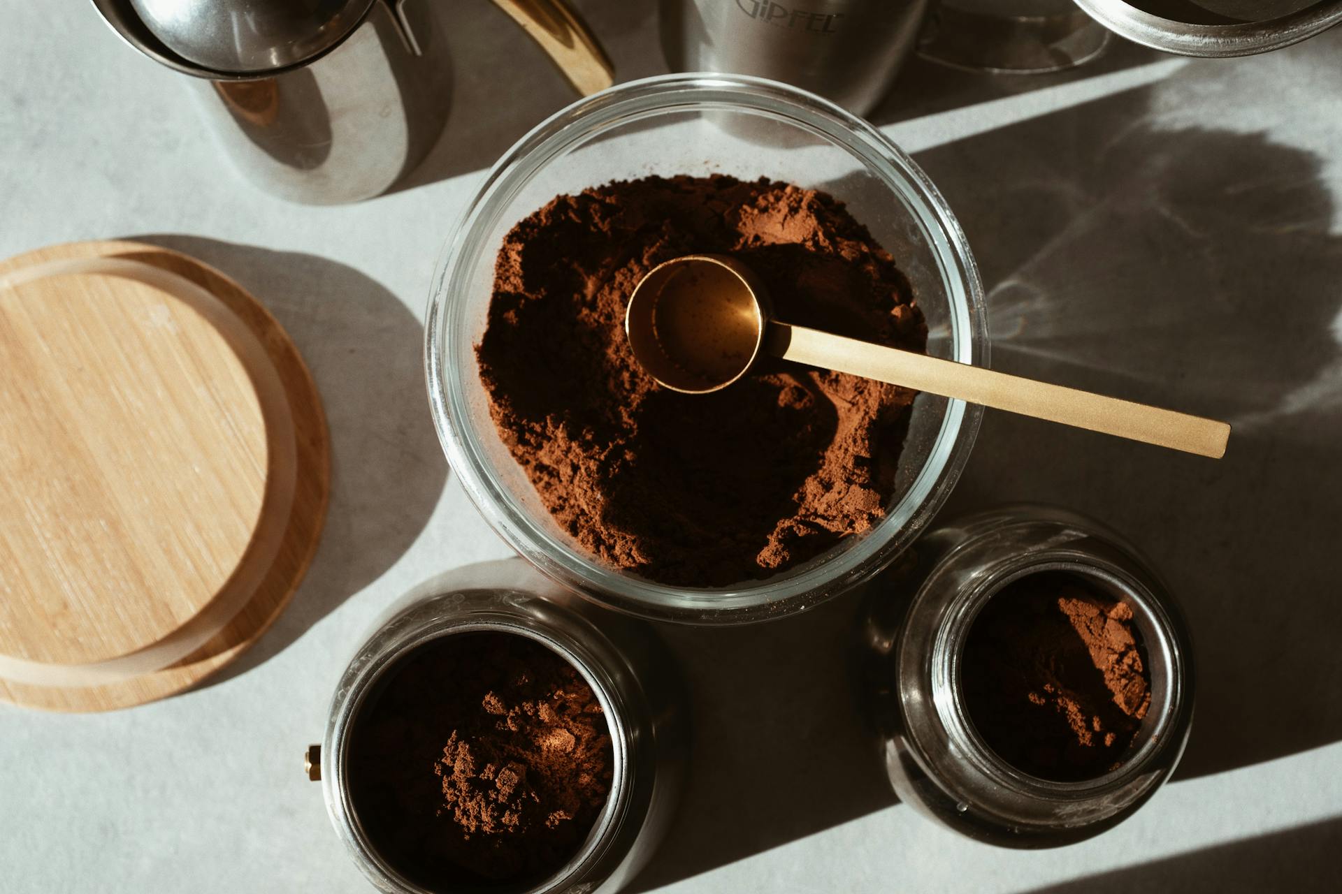 Ground coffee in glass jars and a wooden-lid storage canister