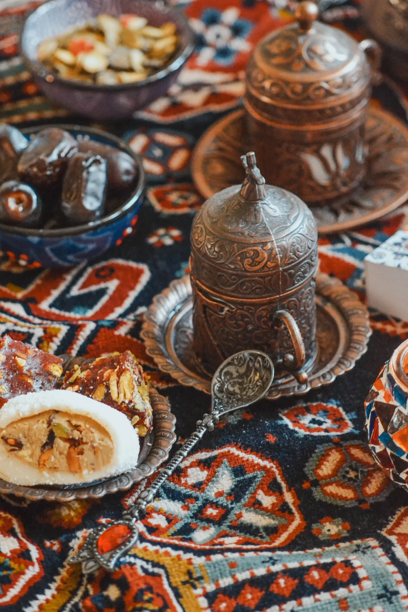 A cezve and Turkish coffee served with sweets on a patterned rug